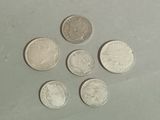 six different coins are arranged in a circle on a table