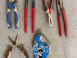 many different types of pliers on the floor