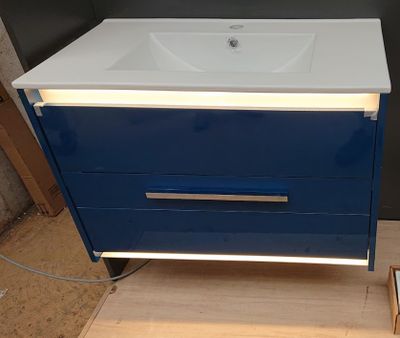 a blue and white bathroom vanity with a mirror above it