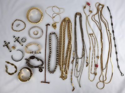 de nombreux types de colliers et de bracelets disposés sur un lit