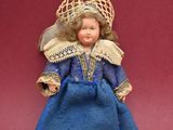 a small doll that is sitting on a red surface