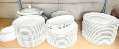 many plates and cups stacked on a shelf in a kitchen