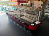 tables and chairs in a restaurant with a glass counter and a red and black counter top