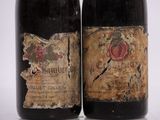 two bottles of wine sitting next to each other on a white surface
