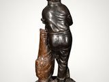bronze statue of a boy with a bag and a fish