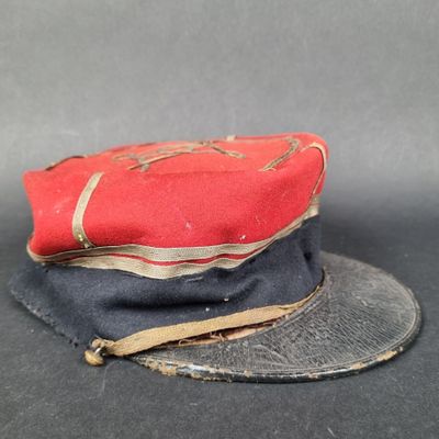 un chapeau rouge et noir posé sur un chapeau noir