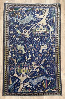 un tapis bleu orné d'oiseaux et de fleurs posé sur un parquet