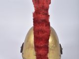 a gold helmet with a red tail on it