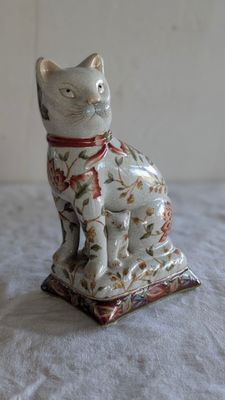 une figurine de chat posée sur une table blanche
