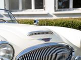 a white car parked in front of a white house