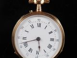 une montre de poche en or avec des chiffres romains sur le cadran