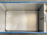 a white and blue cooler with a lot of food inside of it