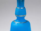 a blue glass bottle with a gold rim on it