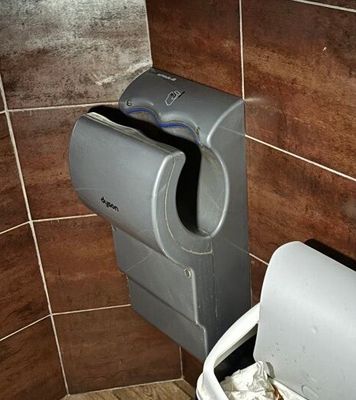 des toilettes dans une salle de bains, avec un distributeur de papier à côté
