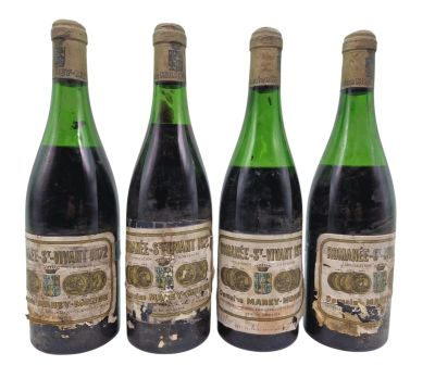 trois bouteilles de vin posées les unes à côté des autres sur une surface blanche