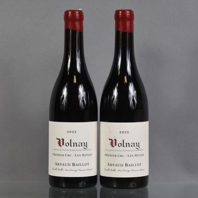 two bottles of red wine sitting on top of a table