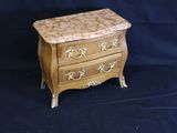a small wooden chest of drawers on a black background
