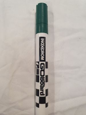 a close up of a green marker pen on a white sheet