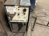 a machine that is sitting on the ground next to a barrel
