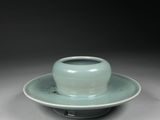 a green cup and saucer sitting on a saucer