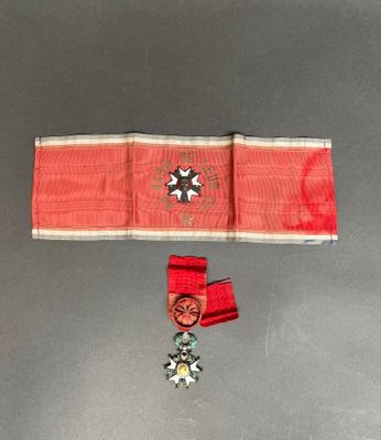 une image représentant un ruban rouge orné d'une croix et d'une médaille