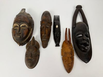 Plusieurs masques africains sont exposés sur un fond blanc