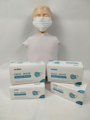 trois boîtes de masques posées à côté d'une tête de mannequin