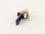 a small figurine of a man laying on the ground
