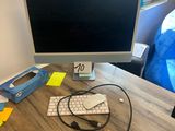 un écran d'ordinateur posé sur un bureau avec un clavier et une souris