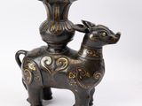 une statue représentant une vache surmontée d'un vase