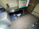 une cuisine équipée d'un plan de travail en inox et d'un lave-vaisselle