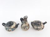 three teapots sitting next to each other on a white surface