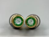 pair of green and gold wine bottles sitting on top of a white surface