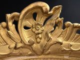 a large gold mirror with a flower decoration on it