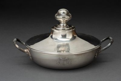 une cocotte en argent avec un couvercle posée sur une table