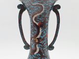 a blue vase with a snake on it sitting on a table