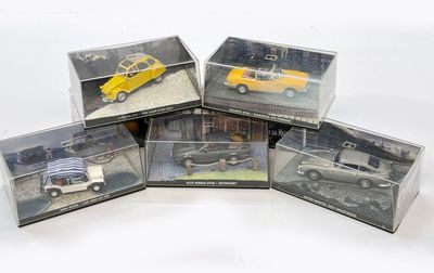 quatre boîtes contenant des petites voitures sont disposées sur une surface blanche