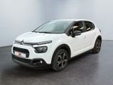 Une Citroën blanche est garée dans une pièce blanche