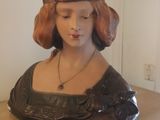 a bust of a woman sitting on top of a wooden table