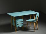 turquoise desk and chair in a dark room with a dark wall