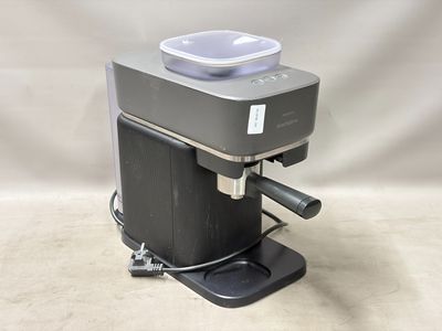 une image représentant une machine à café surmontée d'un récipient en plastique