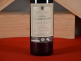 a bottle of wine sitting on a table next to a wooden crate