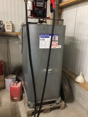 un chauffe-eau installé dans un garage, auquel est raccordé un tuyau
