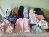 a lot of clothes that are sitting on a bed