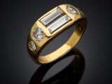 a yellow gold ring with a baguet and three diamonds