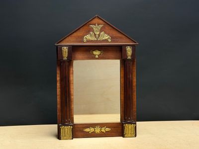 une photo représentant un petit miroir posé sur une table en bois