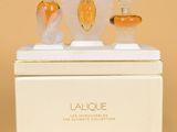 trois flacons de parfum posés sur une boîte blanche