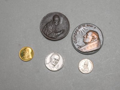 plusieurs pièces de monnaie et une pièce sur laquelle figure l'effigie d'un homme