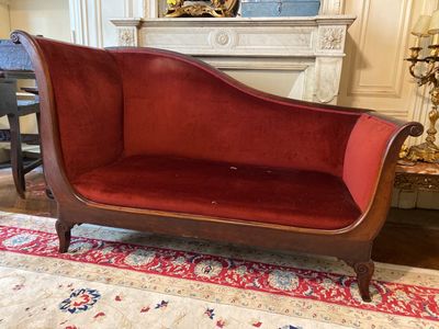 a red couch sitting on a rug in a living room