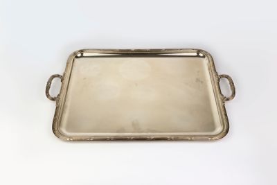un plateau en argent avec des poignées et des poignées sur une surface blanche